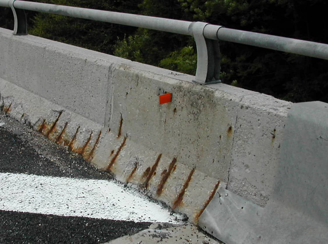 Exposed reinforcement on a concrete barrier from carbonation