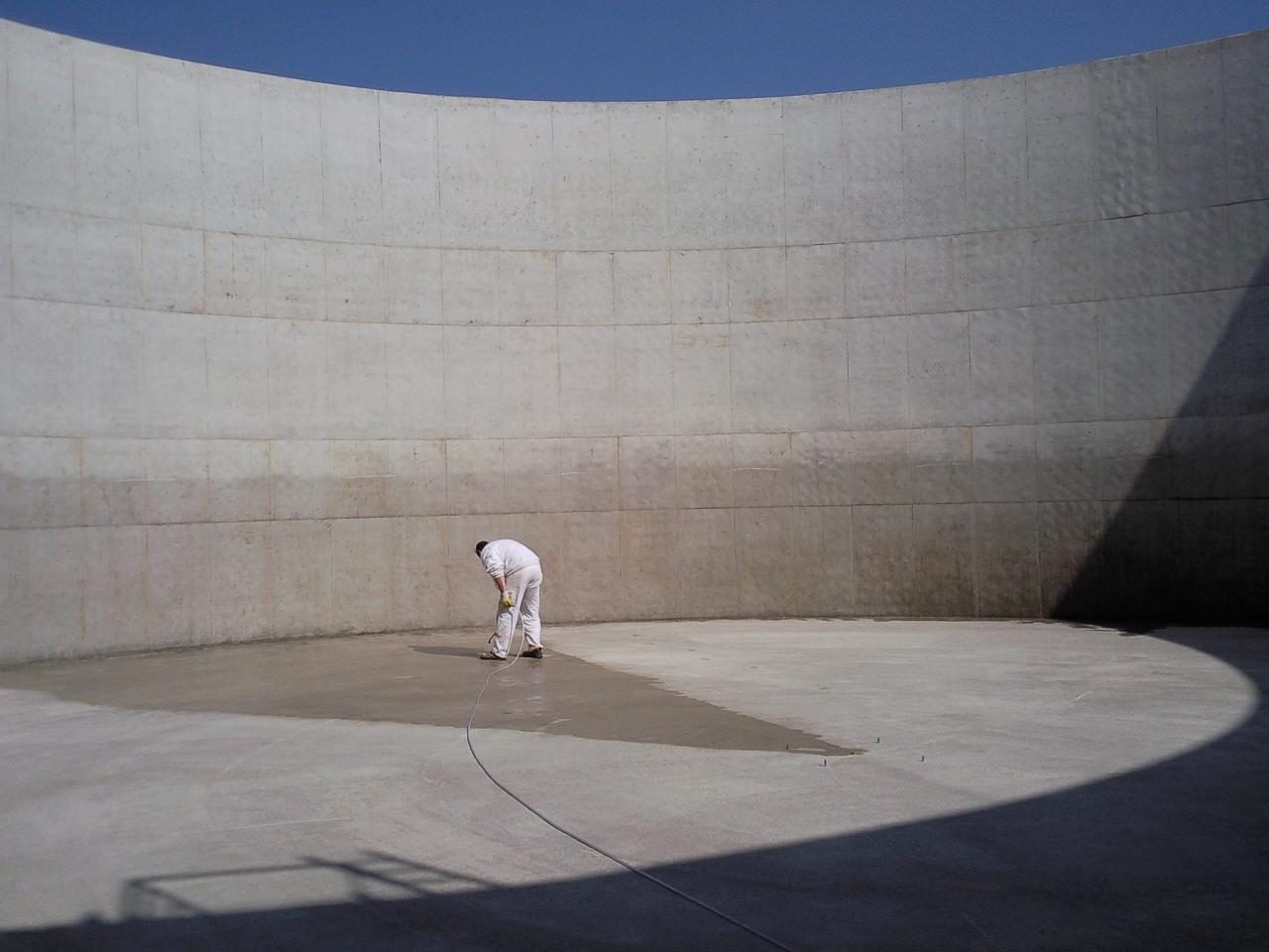 Spraying Evercrete Vetrofluid on the floor of a concrete biogas tank