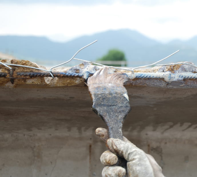 Brush application of Rust Buster rust converter on reinforcing bars