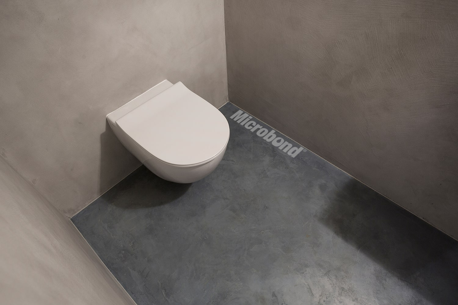 Small bathroom covered in decorative Microbond mortar on the walls and floor